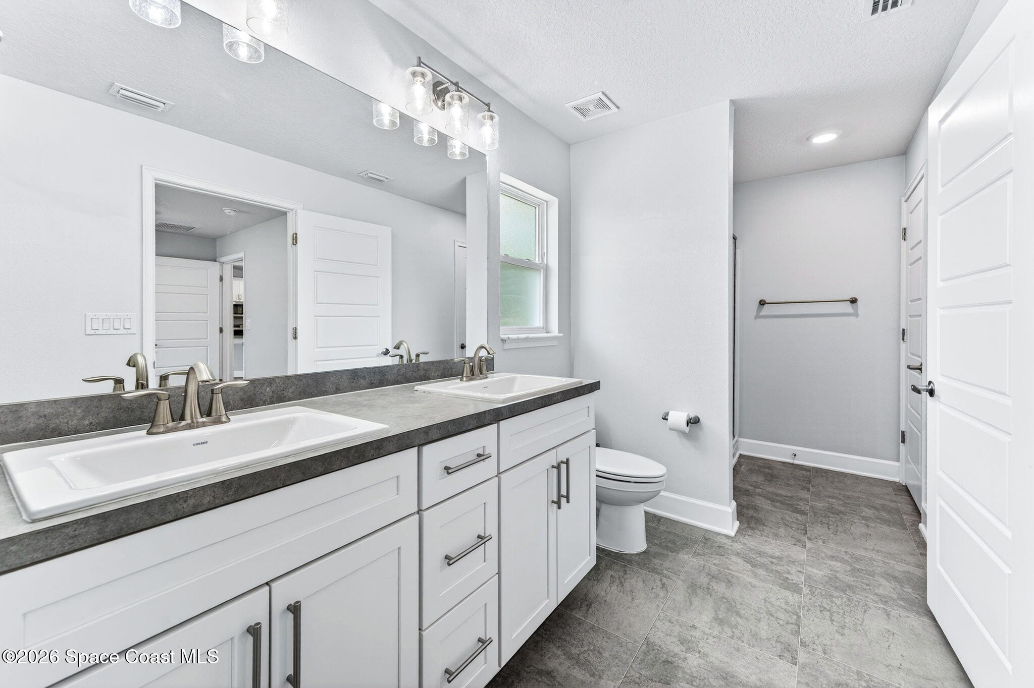 717 Gelaso Street Southwest Palm Bay, FL 32908 - Photo 24 of 48 a spacious bathroom with a granite countertop sink a toilet and a mirror