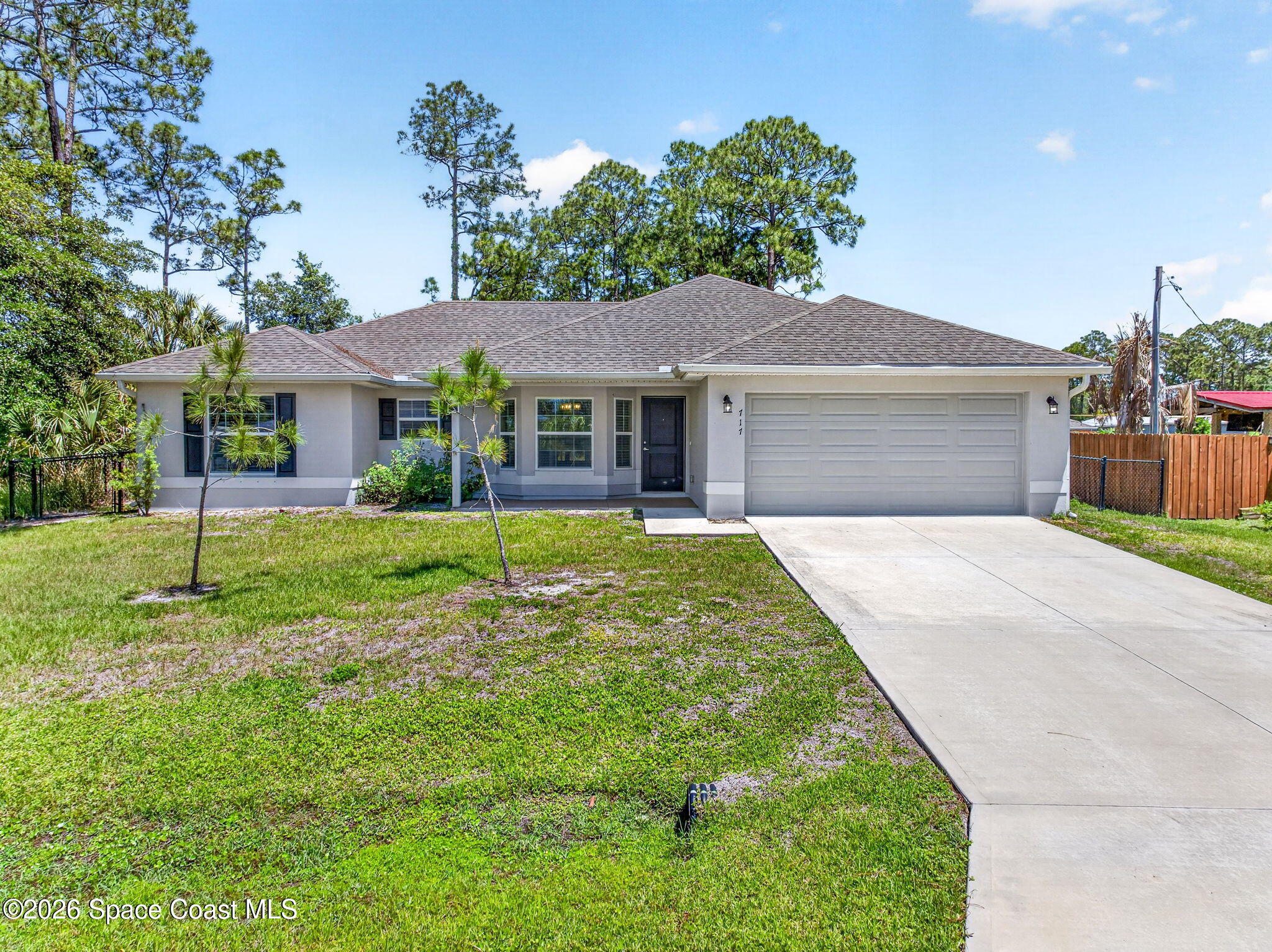 717 Gelaso Street Southwest Palm Bay, FL 32908 - Photo 9 of 48 a front view of a house with a yard and garage