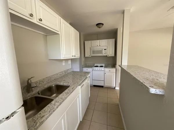 a kitchen with a sink stove top oven and cabinets