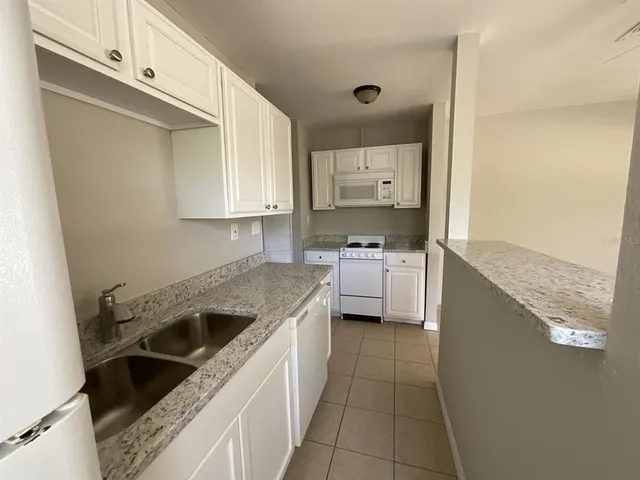 a kitchen with a sink stove top oven and cabinets