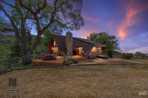 a view of a house with backyard and trees