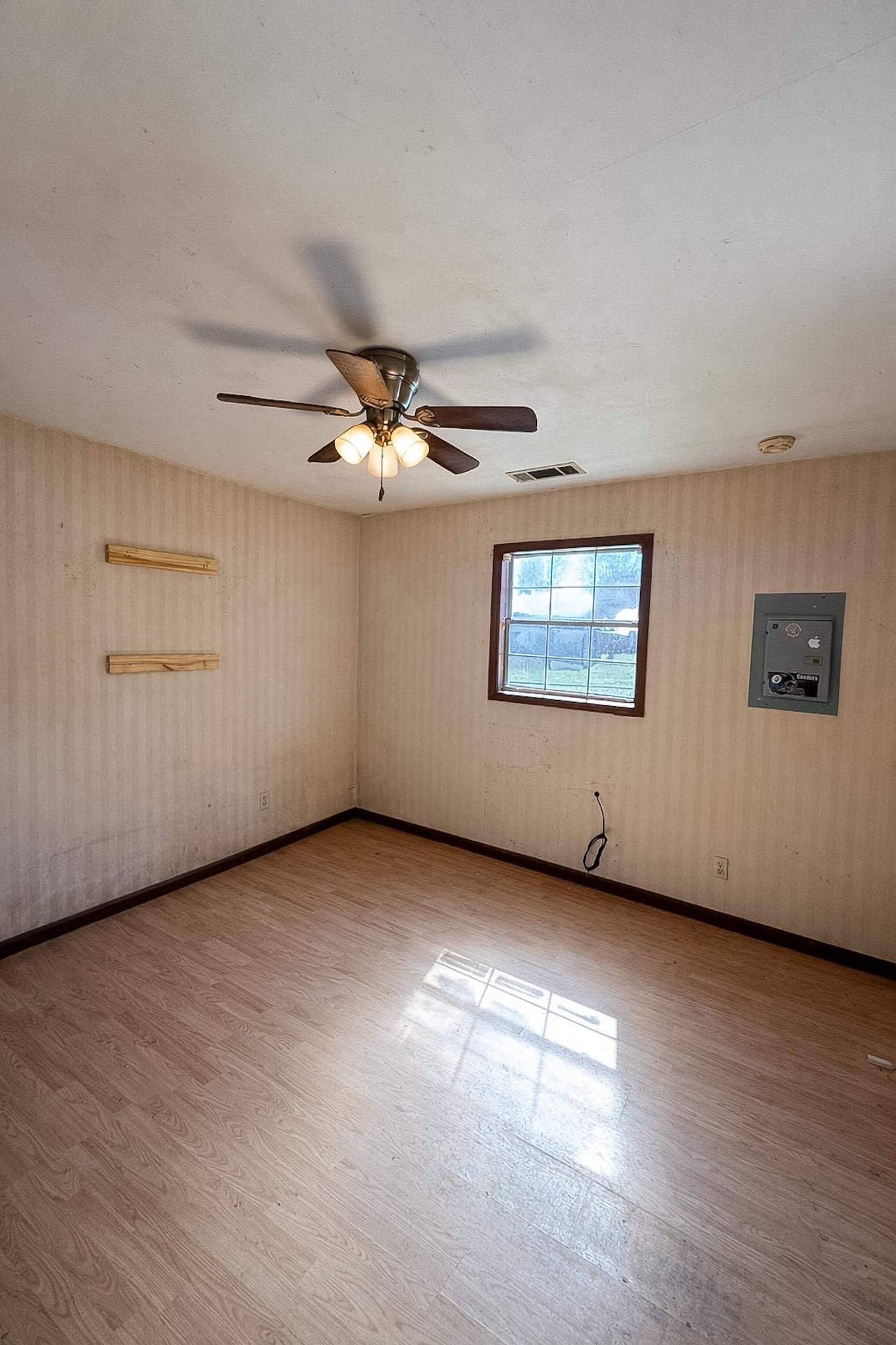 7394 Benjestown Road Millington, TN 38053 - Photo 3 of 6 Unfurnished room with electric panel, light wood-style floors, and ceiling fan