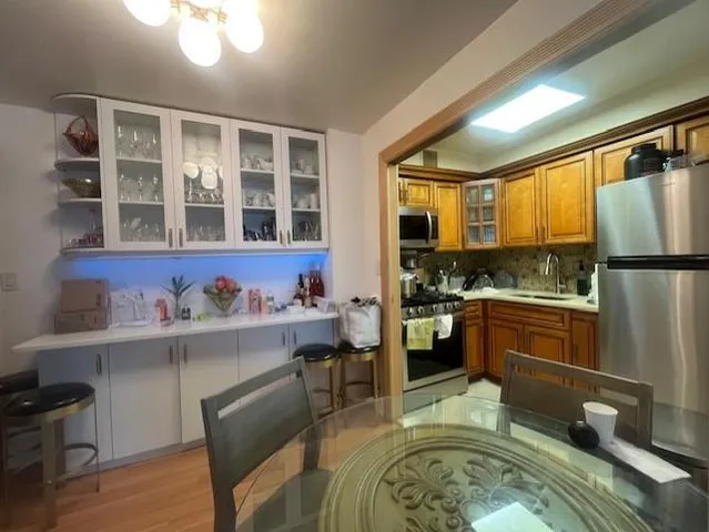 a kitchen with a refrigerator and wooden cabinets