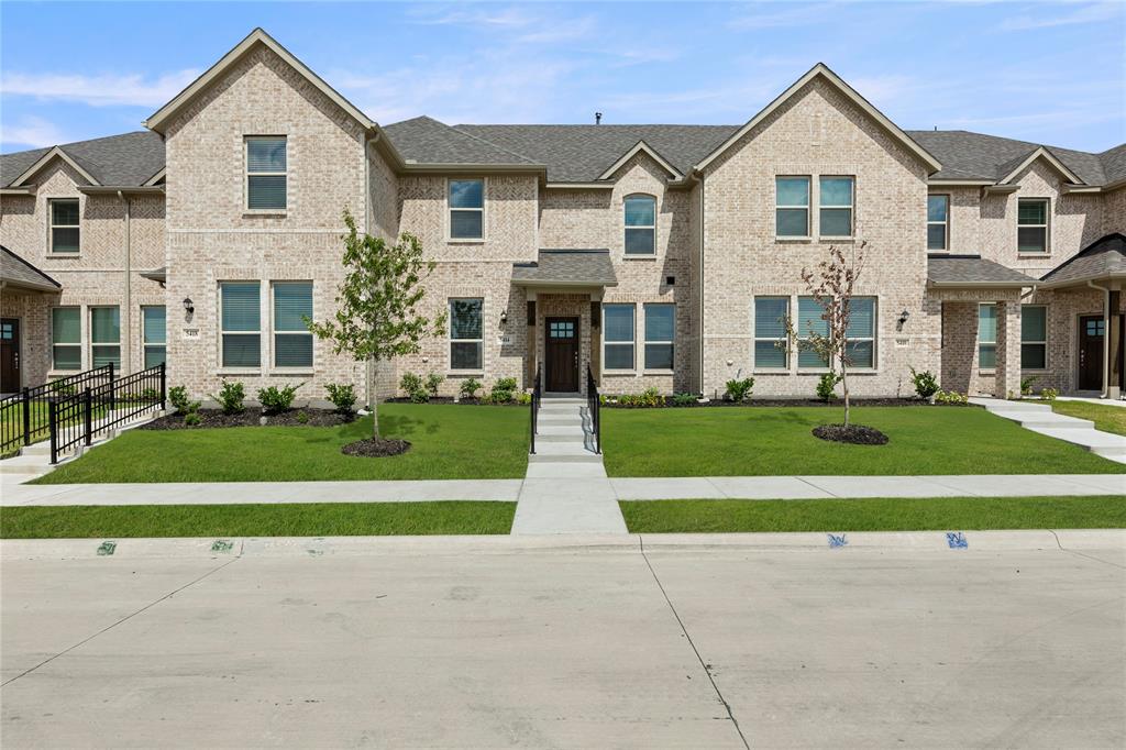 a front view of a house with a yard and trees
