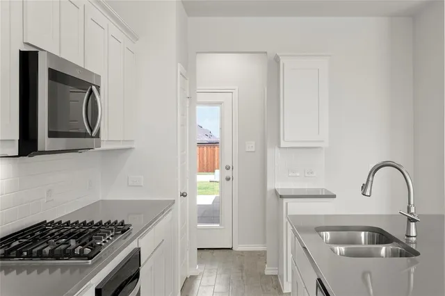 a kitchen with sink a stove and refrigerator