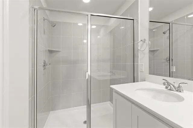 a bathroom with a granite countertop shower sink and mirror