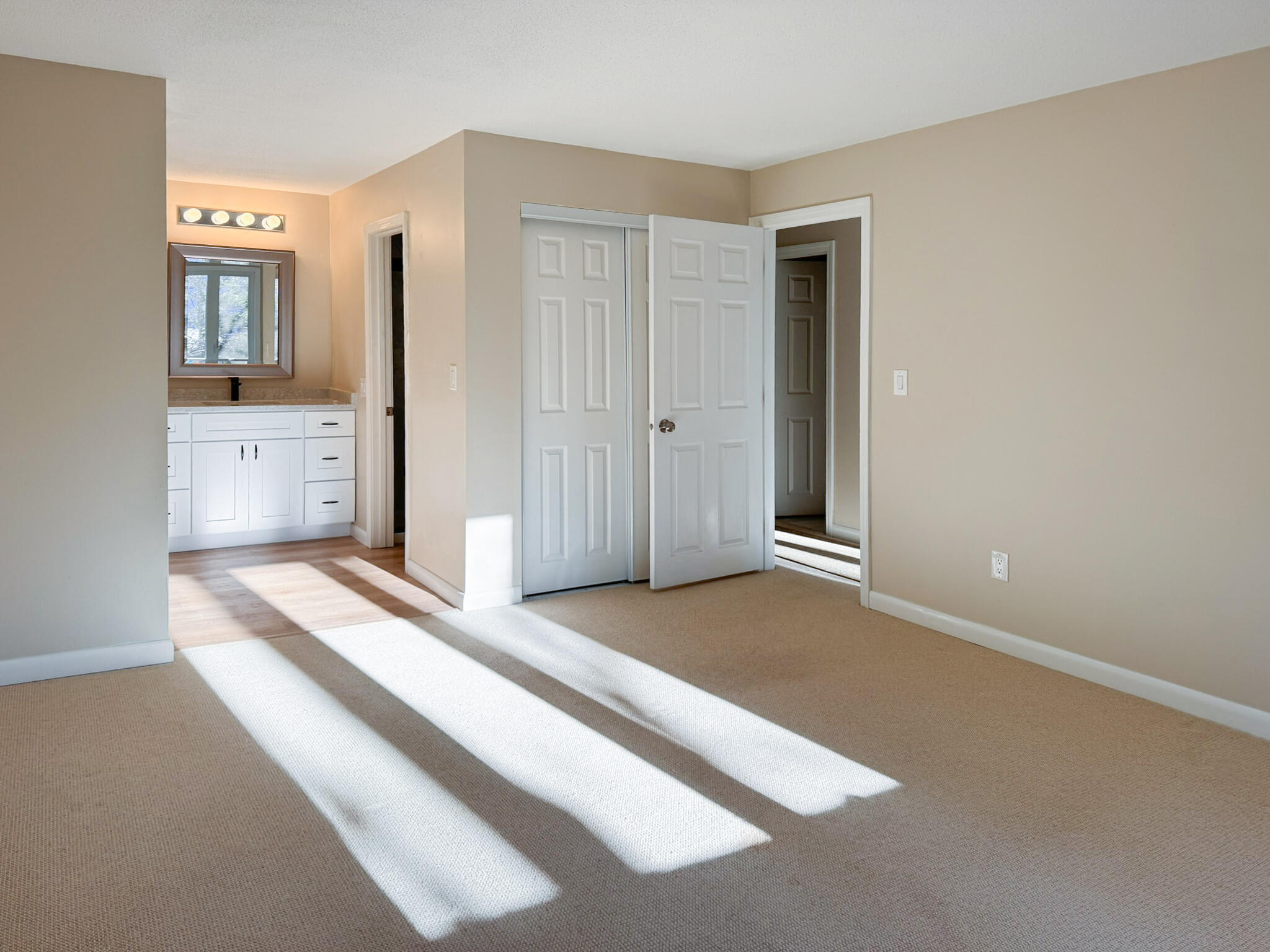 225 SW Meadows, Unit 225 Teaticket, MA 02536 - Photo 21 of 27 a spacious bedroom with a bed and a lamp on dresser