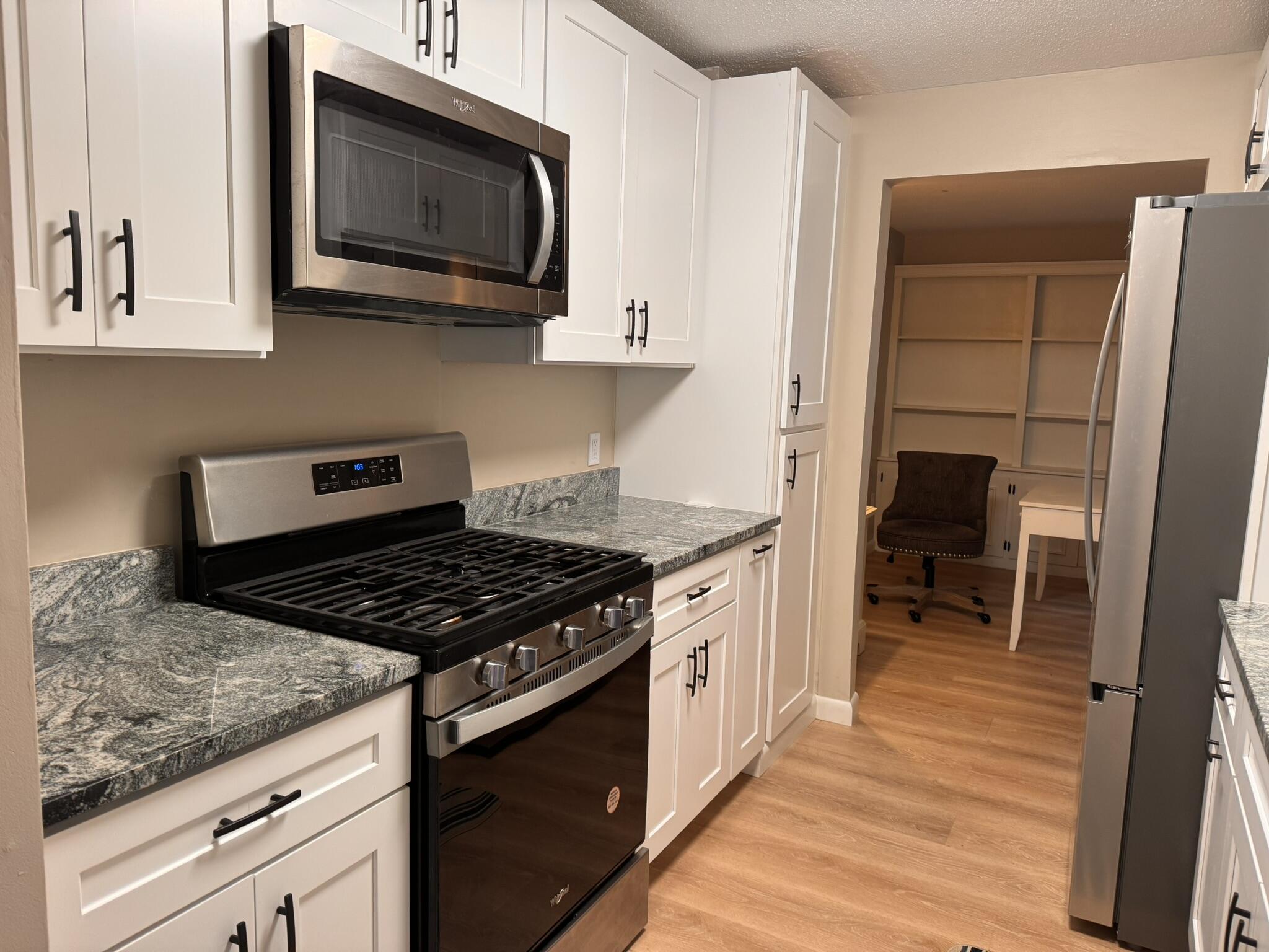225 SW Meadows, Unit 225 Teaticket, MA 02536 - Photo 3 of 20 a kitchen with stainless steel appliances granite countertop a stove and a microwave