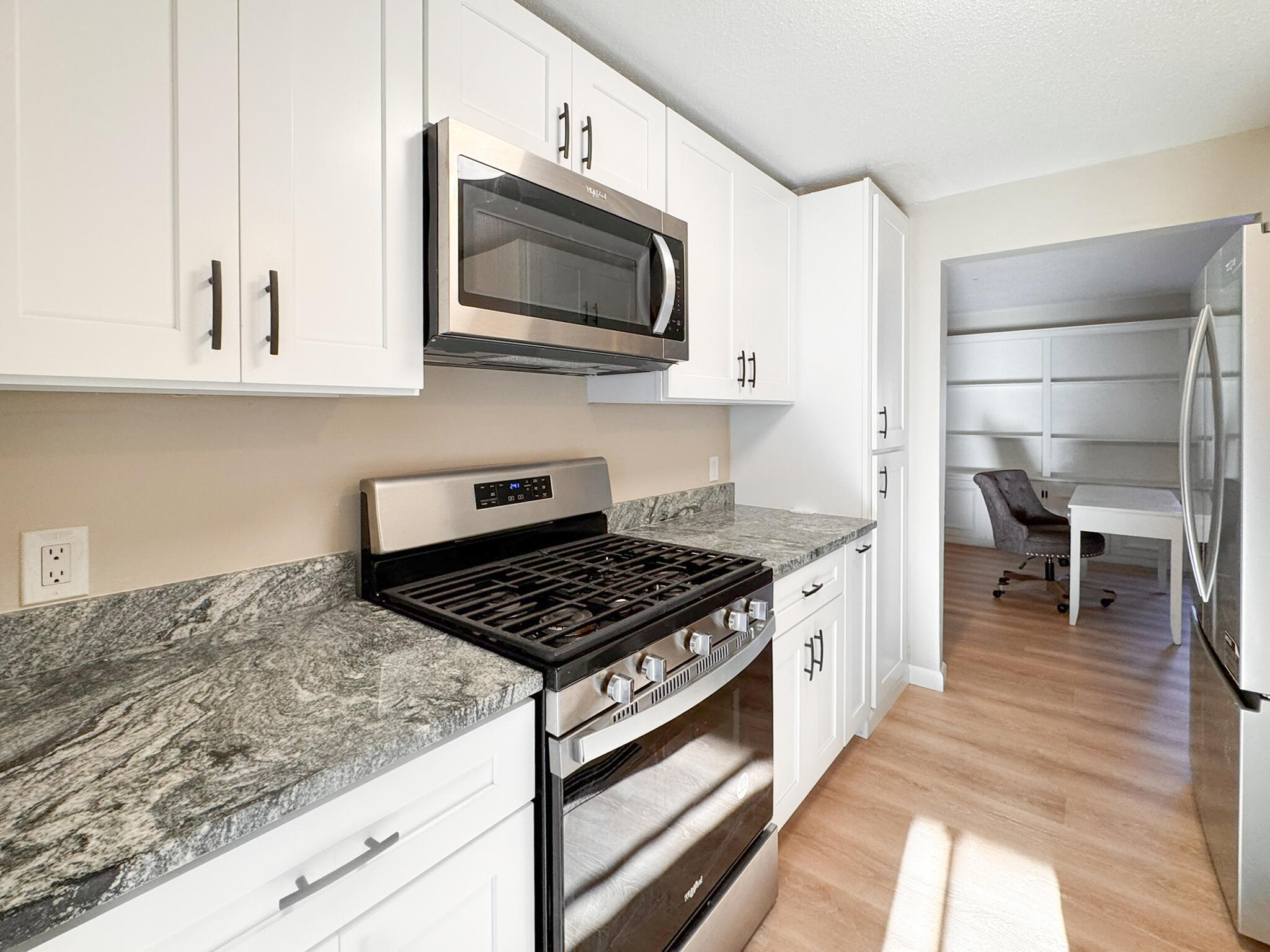 225 SW Meadows, Unit 225 Teaticket, MA 02536 - Photo 7 of 27 a kitchen with stainless steel appliances granite countertop a stove a sink and a microwave