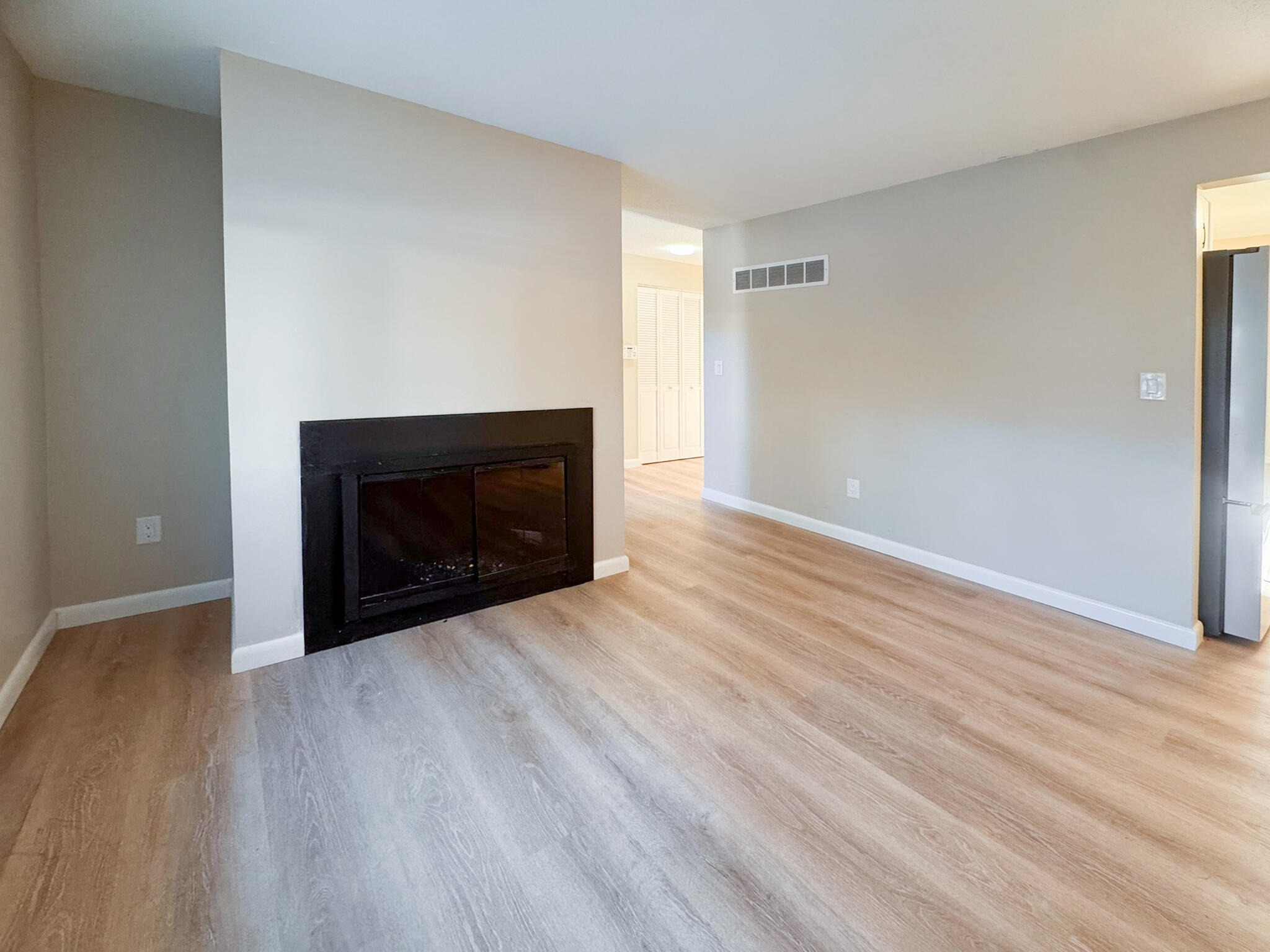 225 SW Meadows, Unit 225 Teaticket, MA 02536 - Photo 10 of 27 a view of an empty room with wooden floor and a fireplace