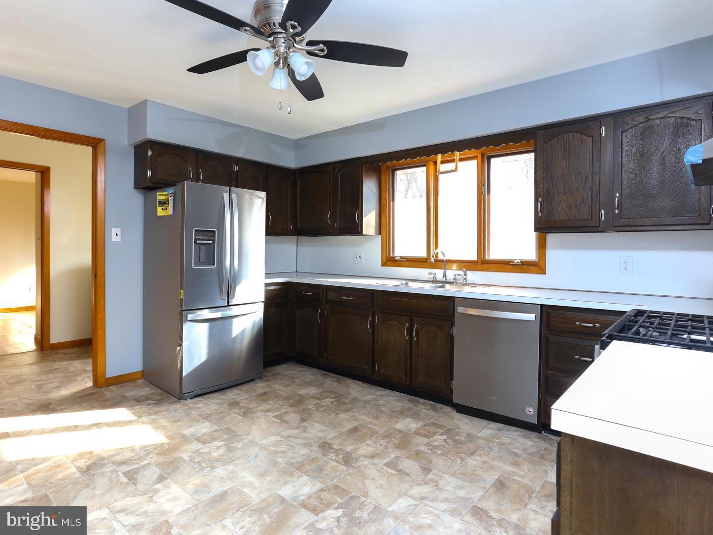 16 Wedge Drive Hamilton, NJ 08610 - Photo 7 of 26 a kitchen with stainless steel appliances granite countertop a refrigerator a sink a stove a microwave and island with wooden cabinets