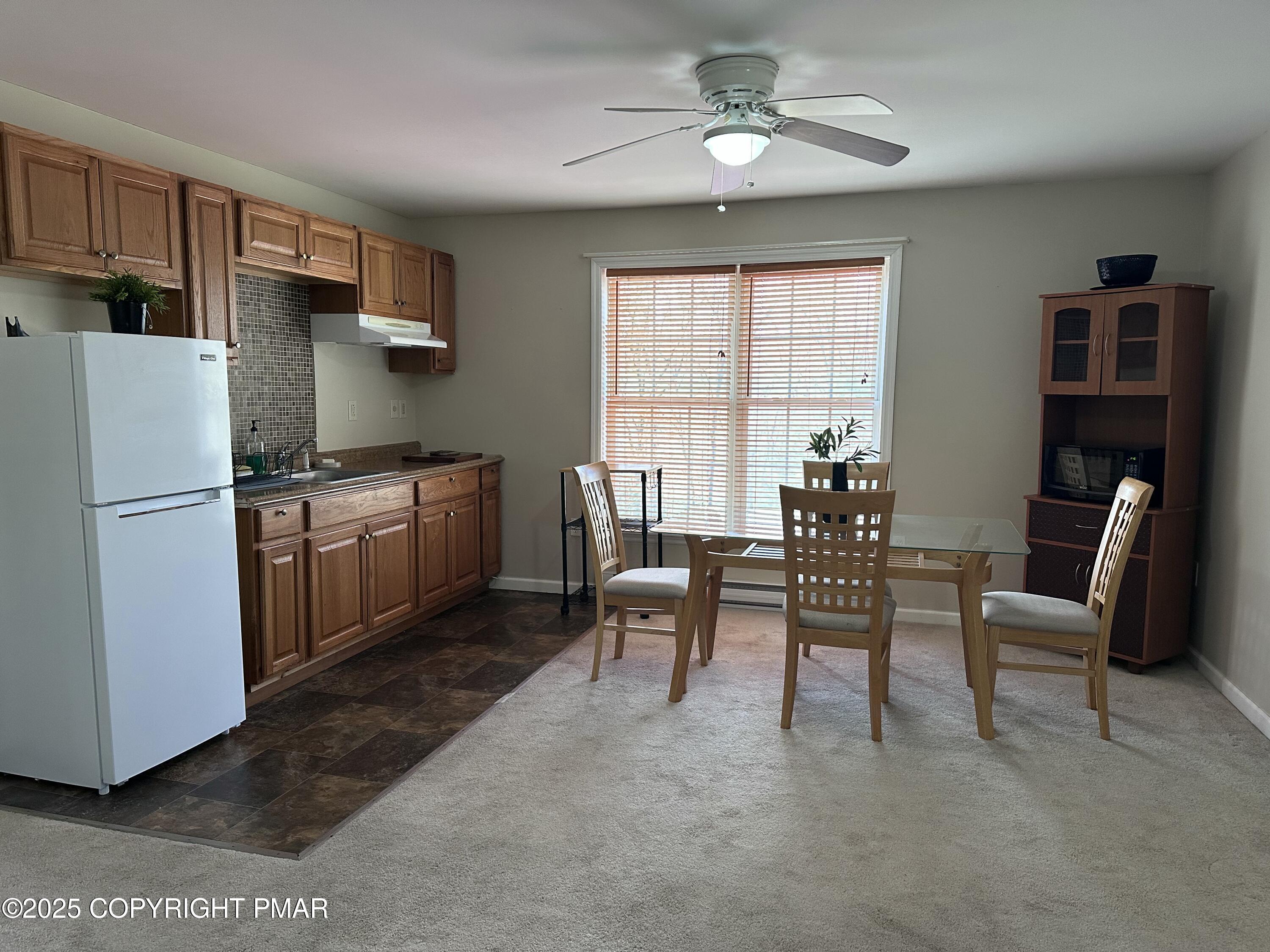5158 Spring Drive Swiftwater, PA 18370 - Photo 3 of 26 a kitchen with stainless steel appliances granite countertop a stove top oven a refrigerator a dining table and chairs with wooden floor
