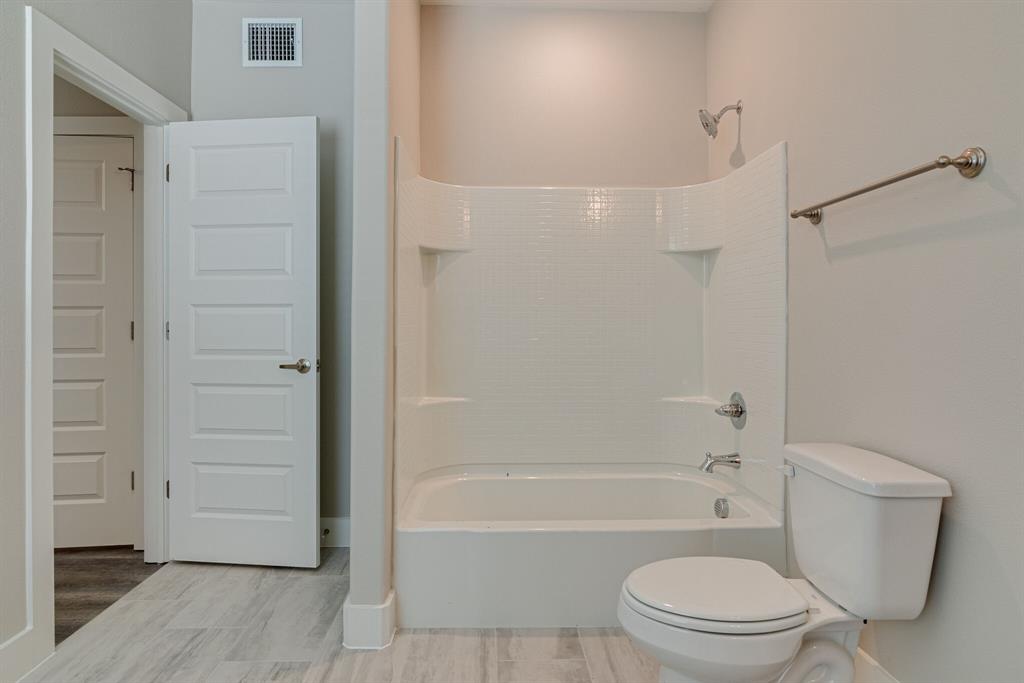 115 West Jones Street, Unit 103 Krum, TX 76249 - Photo 20 of 21 a bathroom with a toilet and a shower