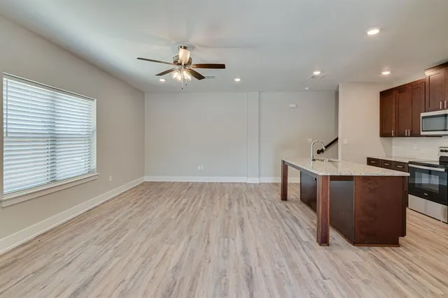 a view of kitchen with sink microwave and wooden floor