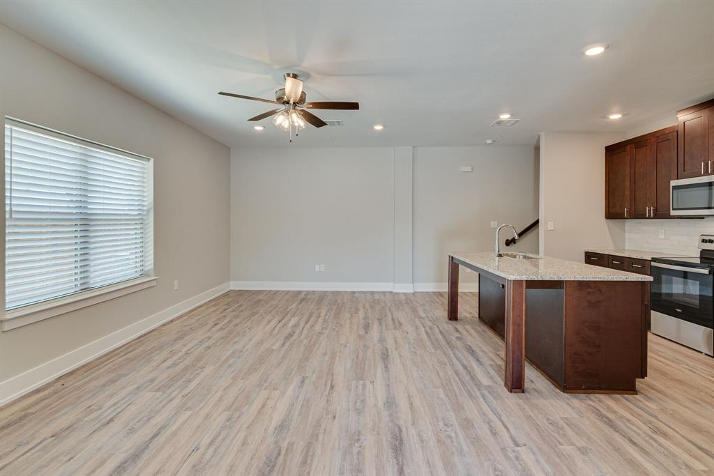 115 West Jones Street, Unit 103 Krum, TX 76249 - Photo 4 of 21 a view of kitchen with sink microwave and wooden floor