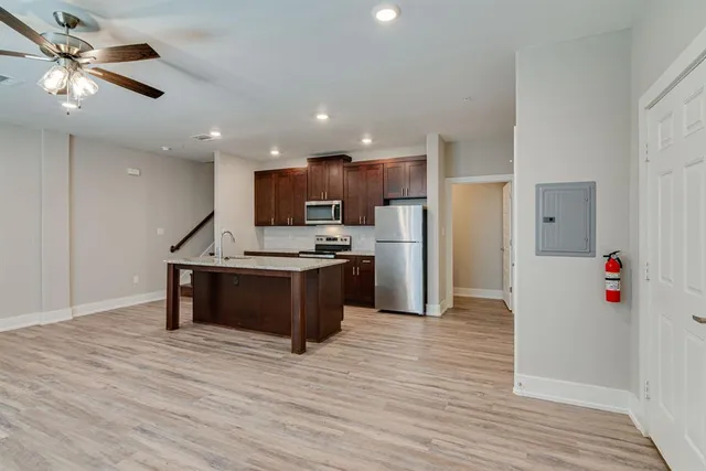a kitchen with stainless steel appliances kitchen island granite countertop a refrigerator and a stove