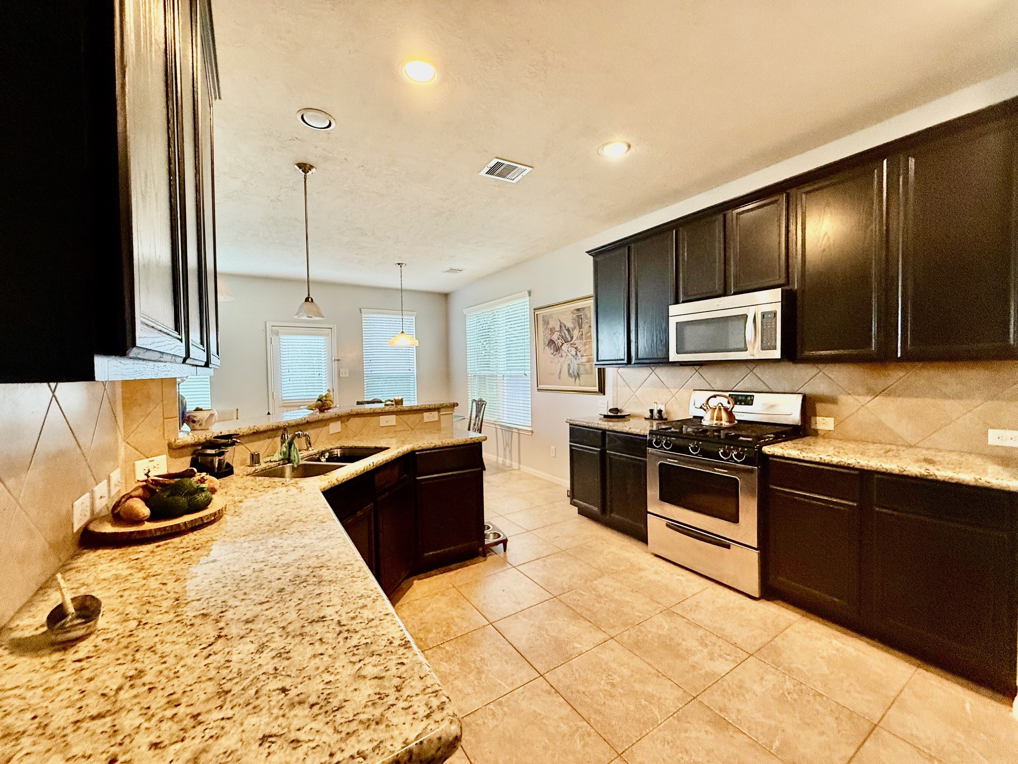 24906 Clover Ranch Drive Katy, TX 77494 - Photo 6 of 13 a large kitchen with kitchen island granite countertop a sink and a stove