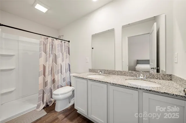 a bathroom with a granite countertop sink toilet and shower