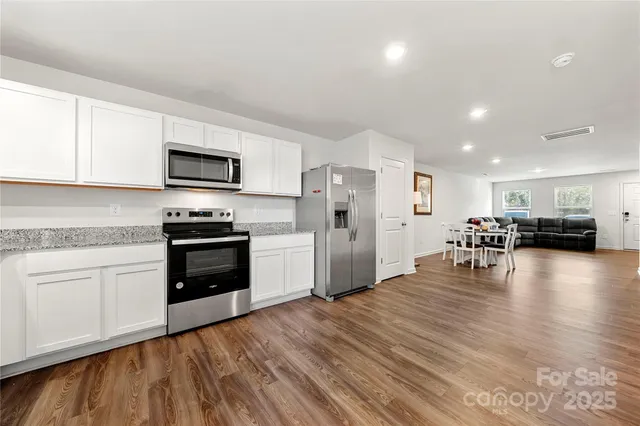 a kitchen with stainless steel appliances a refrigerator stove microwave and cabinets