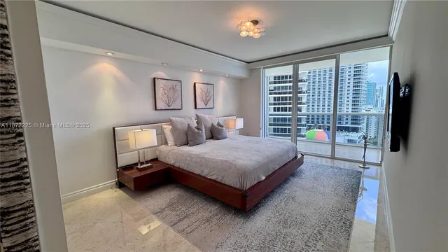 a bedroom with a bed a flat screen tv and a window