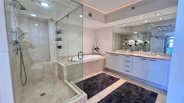 a bathroom with a sink a toilet a shower and a mirror
