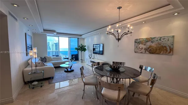 a living room with furniture and a chandelier