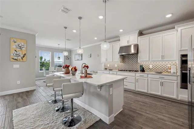 a kitchen with a sink cabinets and wooden floor