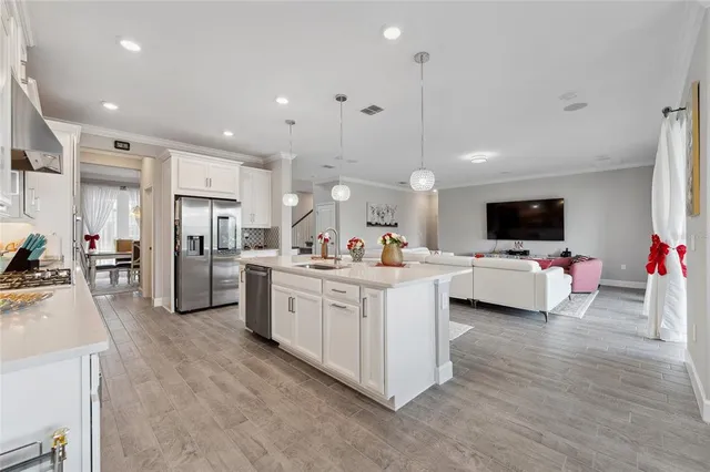 a large white kitchen with a large counter top appliances and cabinets