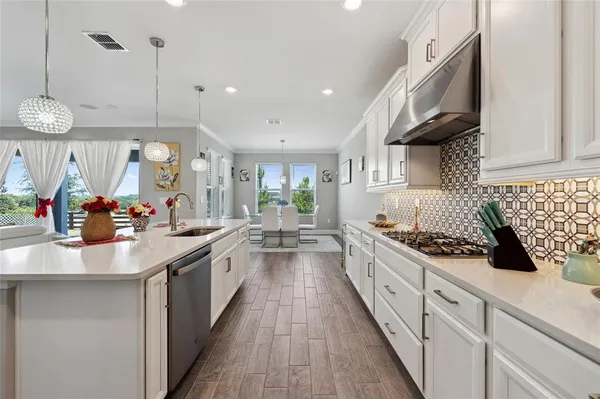 a large kitchen with stainless steel appliances lots of counter space and a sink