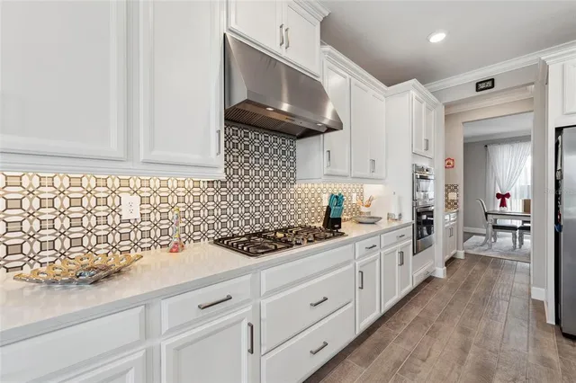 a kitchen with white cabinets and sink