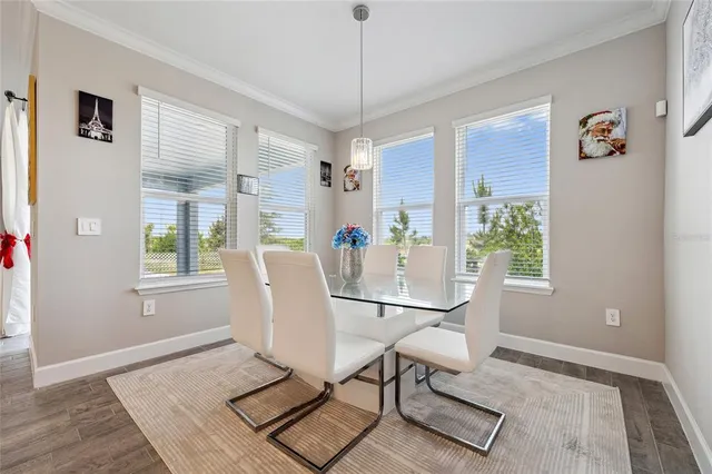 a dining room with furniture a chandelier and wooden floor