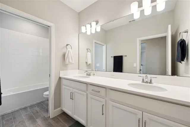 a bathroom with a double vanity sink and a mirror
