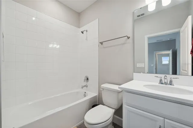 a bathroom with a toilet sink vanity tub and shower