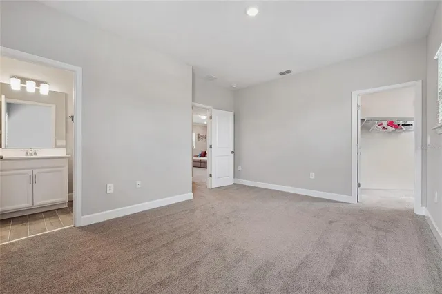 an empty room with a bathroom and mirror