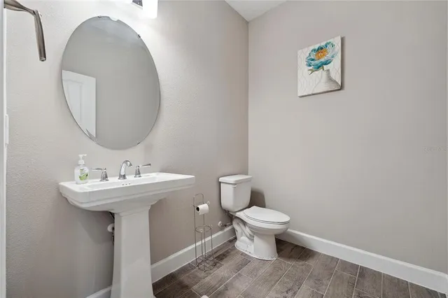 a bathroom with a toilet sink and mirror