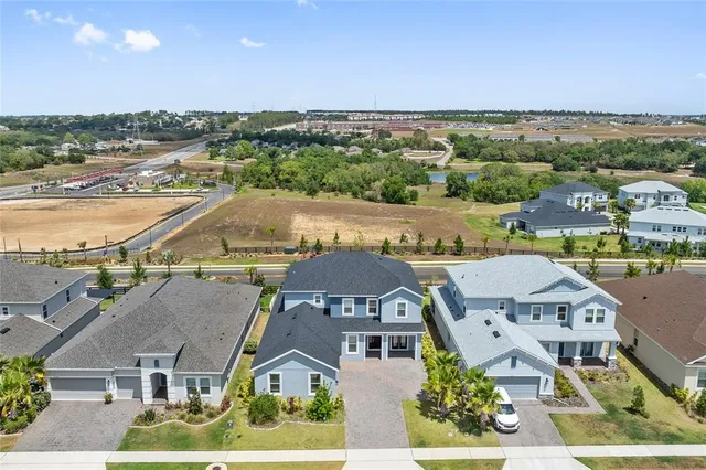 an aerial view of residential houses with outdoor space and ocean view