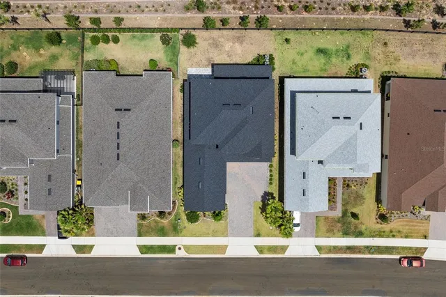 aerial view of a house with a yard and large tree