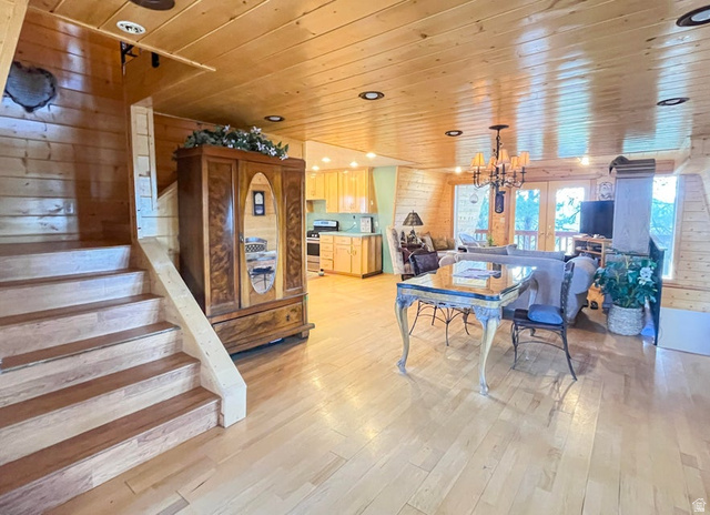 2498 West Silverado Ridge Alton, UT 84710 - Photo 14 of 51 Dining space with wood walls, hanging lights, wooden ceiling, and light wood finished floors