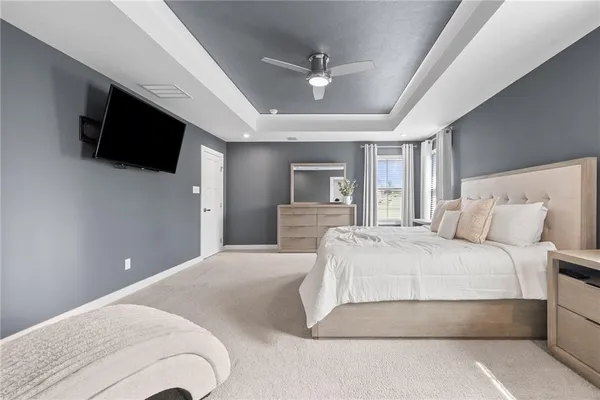 a spacious bedroom with a bed and a flat screen tv