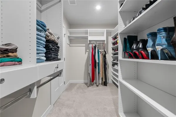 a view of walk in closet with clothes