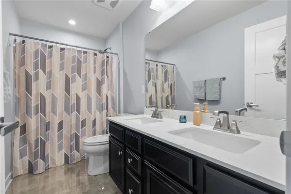 a bathroom with a double vanity sink toilet and a mirror