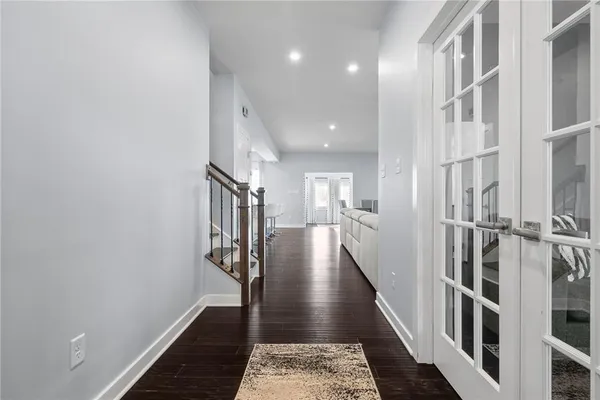 a view of a hallway with wooden floor and staircase
