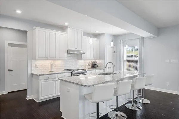 a kitchen with a dining table chairs stove and cabinets
