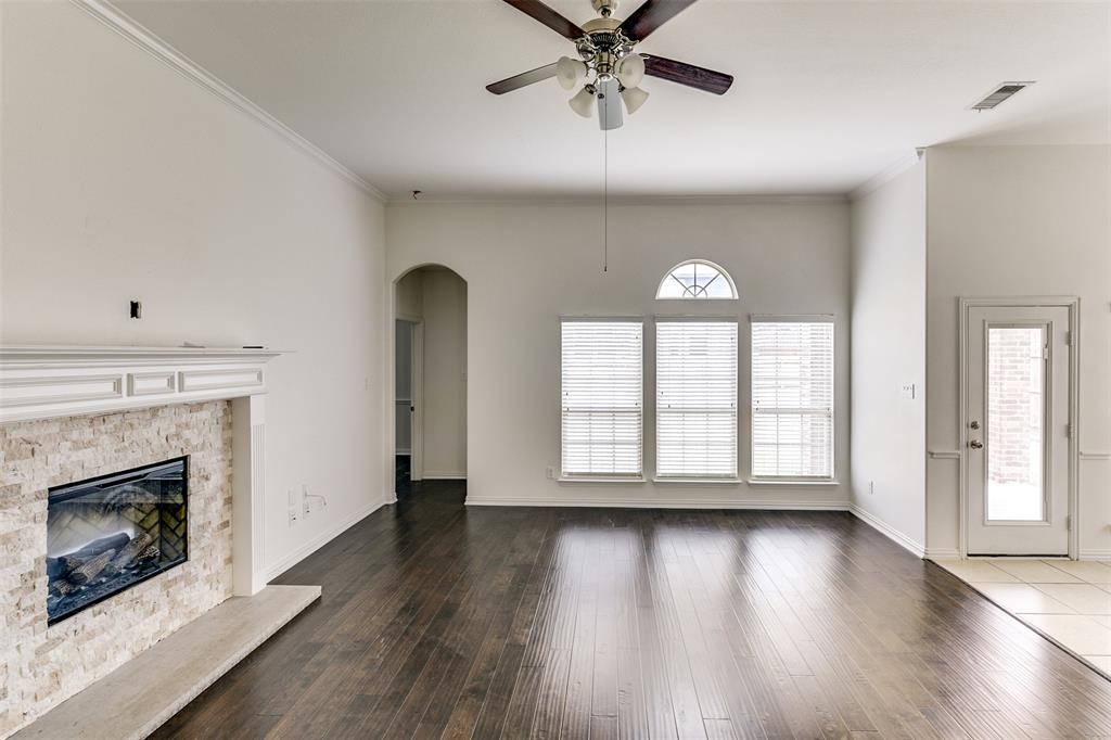 123 Quail Run Road Red Oak, TX 75154 - Photo 11 of 30 an empty room with wooden floor a fireplace and windows