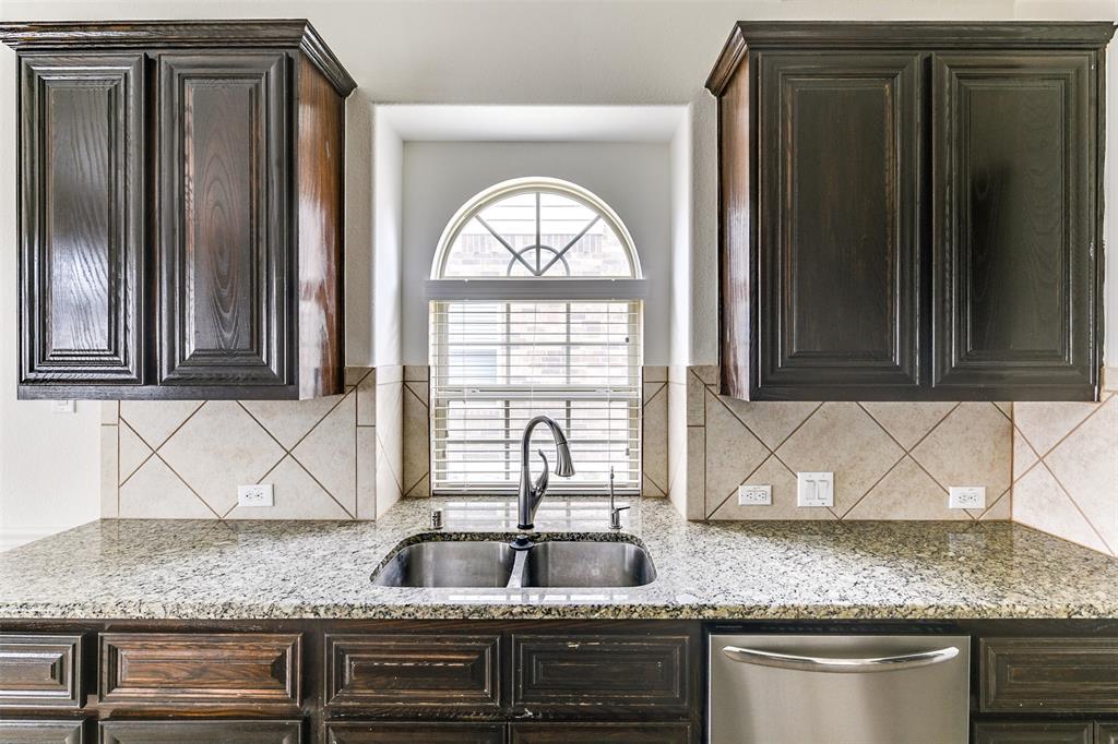 123 Quail Run Road Red Oak, TX 75154 - Photo 16 of 30 a kitchen with granite countertop a sink and a wooden cabinets