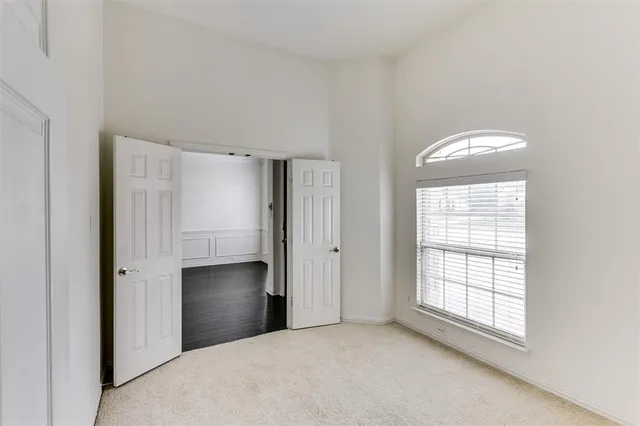 a view of a big room with windows and chandelier fan