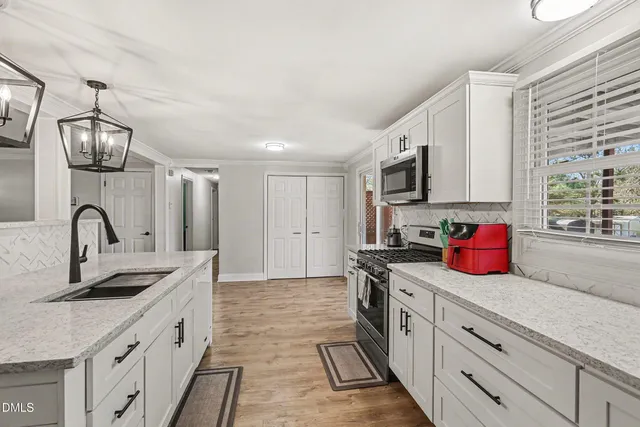 a kitchen with kitchen island granite countertop a sink stainless steel appliances and cabinets