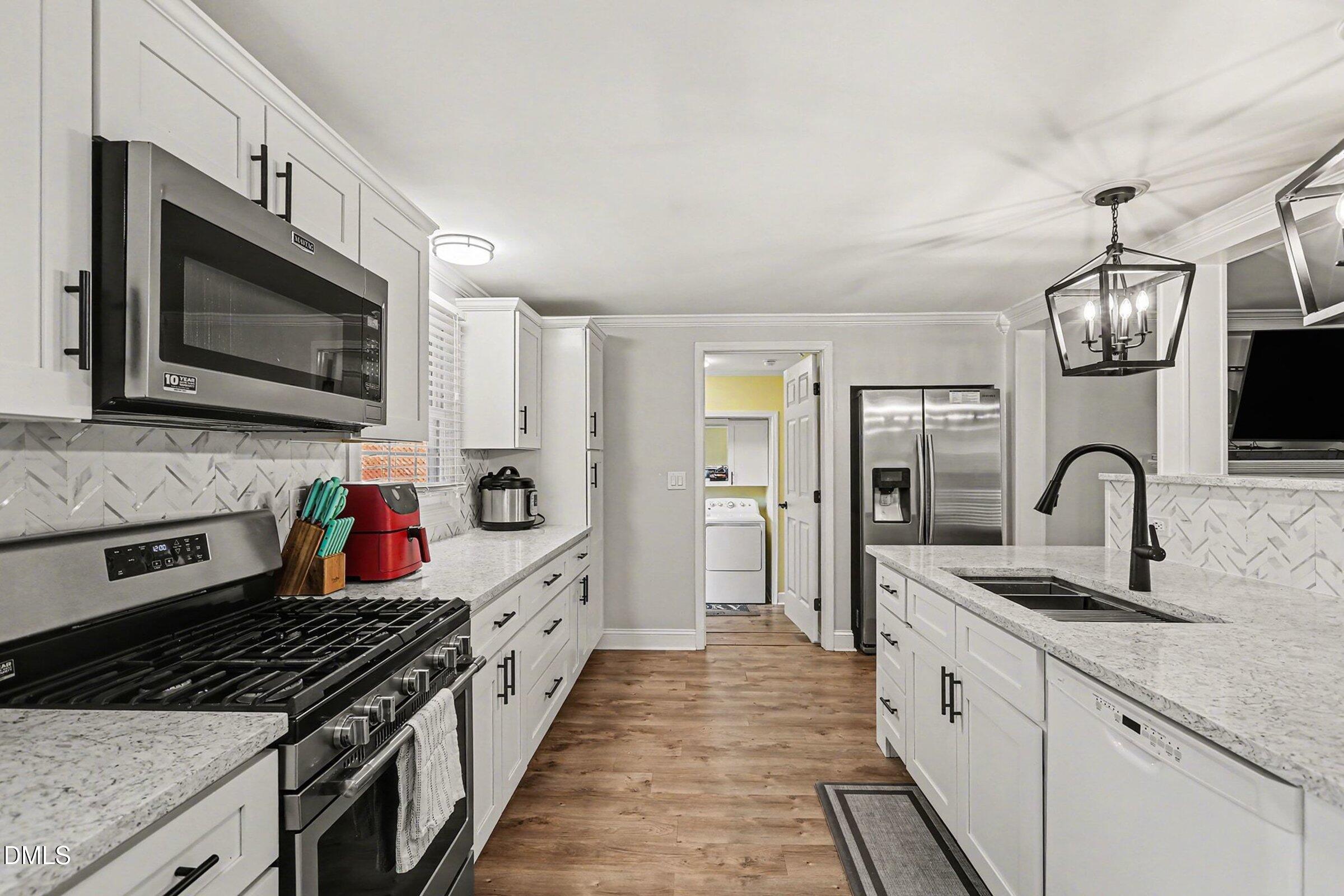 774 Abbott Road Henderson, NC 27537 - Photo 13 of 31 a large kitchen with stainless steel appliances granite countertop a lot of cabinets a stove and a refrigerator