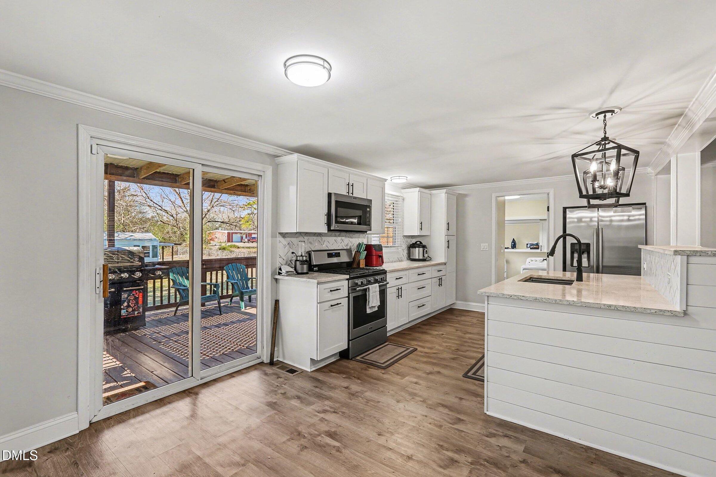 774 Abbott Road Henderson, NC 27537 - Photo 14 of 31 a kitchen with stainless steel appliances kitchen island wooden cabinets and granite counter tops