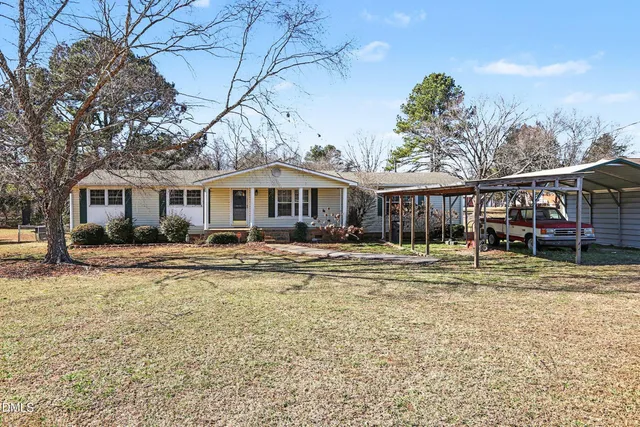 a view of a house with a yard and sitting area